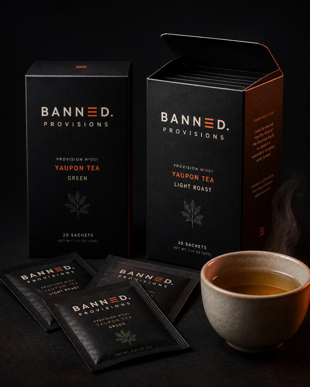 Two Banned Provisions Provision №001 cartons labeled Green and Light Roast, with foil sachets and a ceramic cup of brewed yaupon